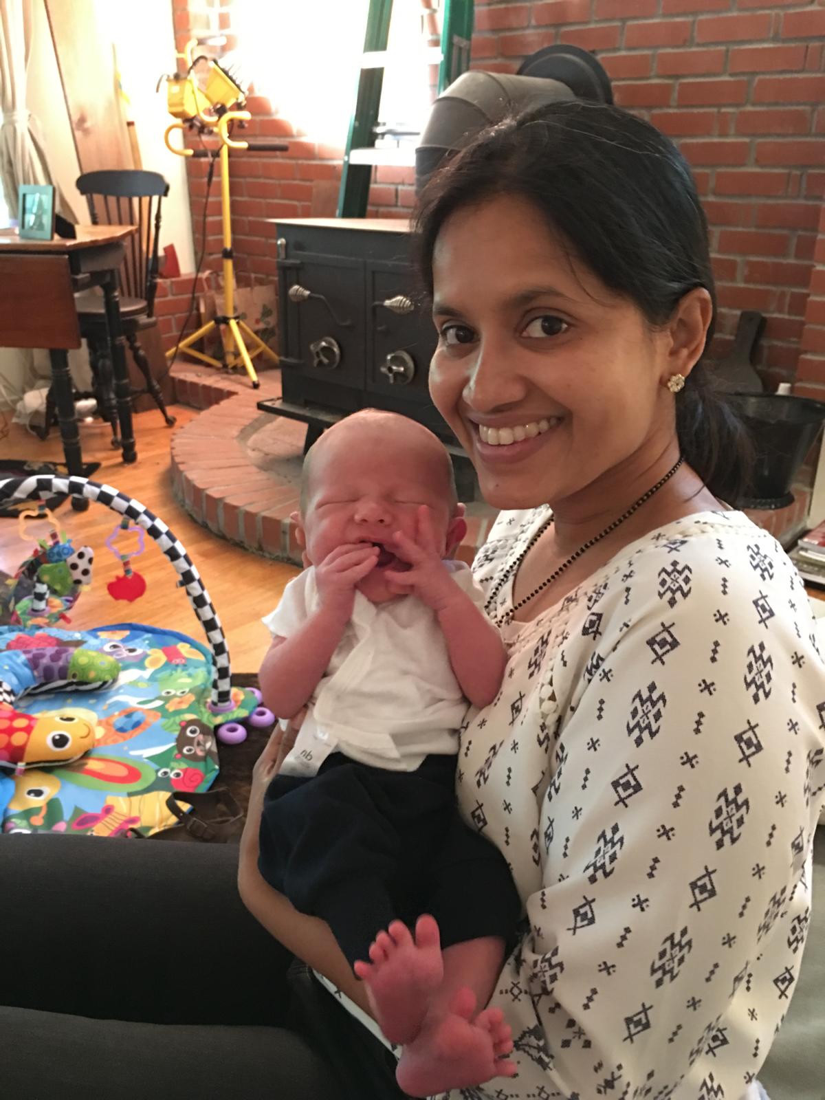 An adult holding a newborn at home